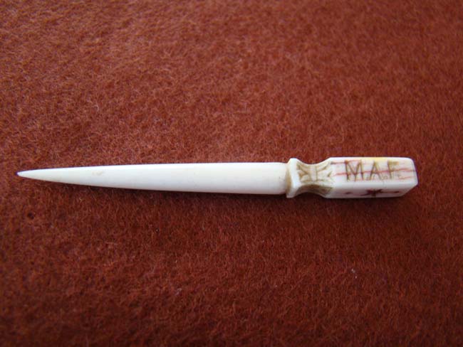 A charming 19th century sailor carved whalebone bodkin with red ink decoration and initials 'M A F'